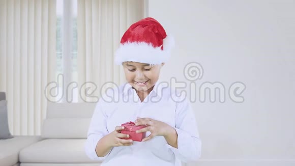 带圣诞帽的男孩打开礼品盒视频的预览图