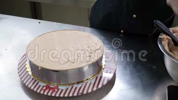 一个糖果师把奶油撒在蛋糕上站在蛋糕架上视频的预览图