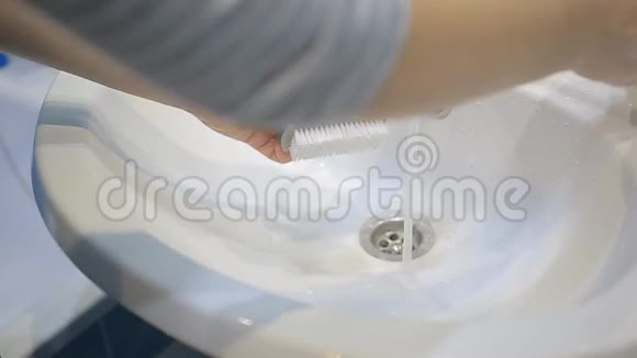 年轻女子用肥皂和洗手池里的刷子洗手视频的预览图