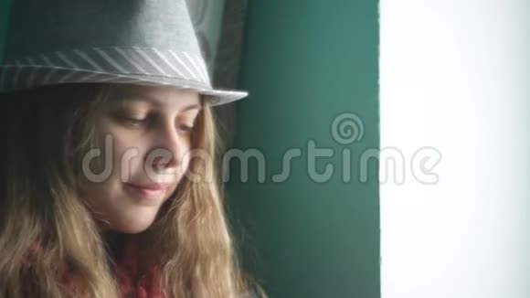 戴着帽子的漂亮年轻女子望着窗外视频的预览图
