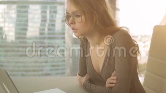 年轻女子用笔记本电脑在城市背景下给朋友打电话视频的预览图