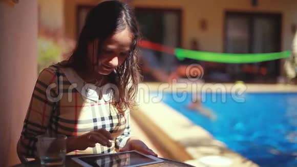 在游泳池背景上有平板电脑的女商人在热带岛屿上喝水1920x1080视频的预览图