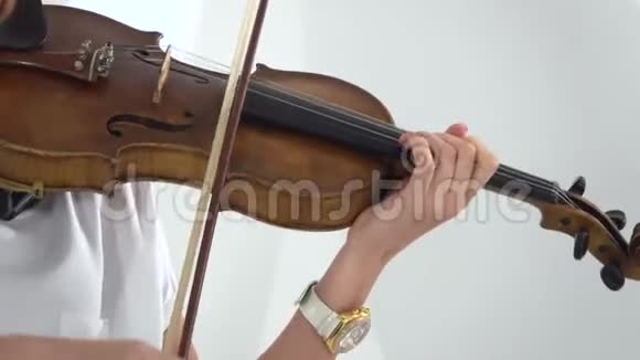 女孩用手指弹奏小提琴的琴弦快关门白色背景视频的预览图