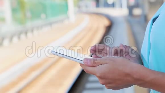 站在火车站里的一位在平板电脑上工作的女商人视频的预览图