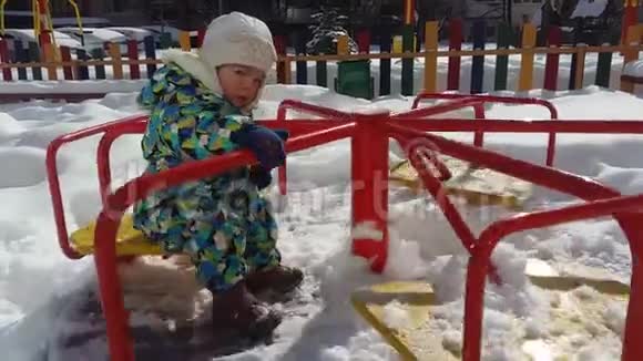孩子在冬天骑旋转木马雪地里的游乐场视频的预览图