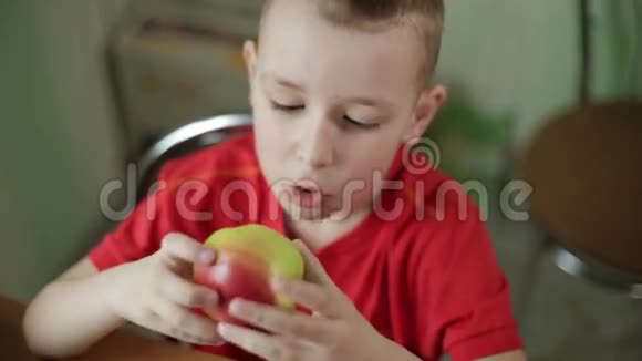 小美丽的男孩大眼睛吃苹果开胃视频的预览图
