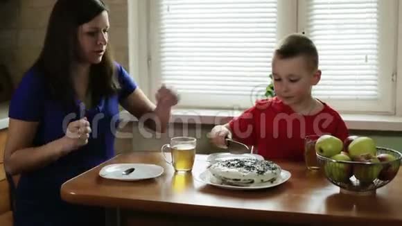 妈妈正在帮小儿子切蛋糕视频的预览图