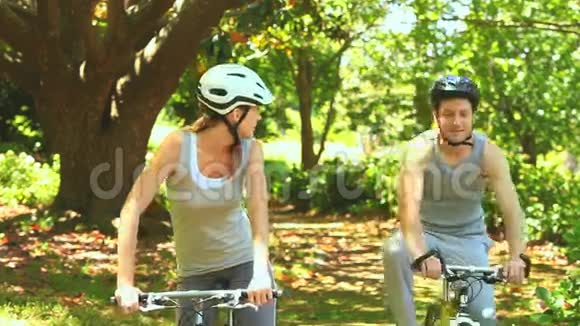 运动夫妇在树林里骑自行车视频的预览图