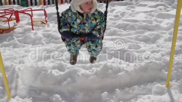 孩子在冬天骑旋转木马雪地里的游乐场视频的预览图