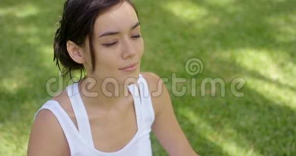 席琳年轻女子在绿色草坪上沉思视频的预览图
