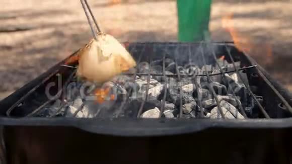 男人用洋葱清洗烤架准备户外烧烤视频的预览图