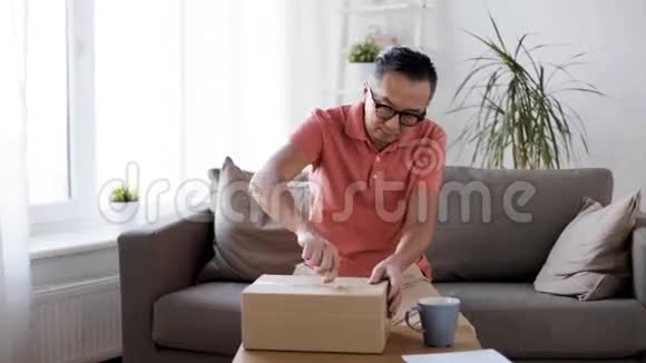 男人在家里用纸刀打开包裹盒视频的预览图