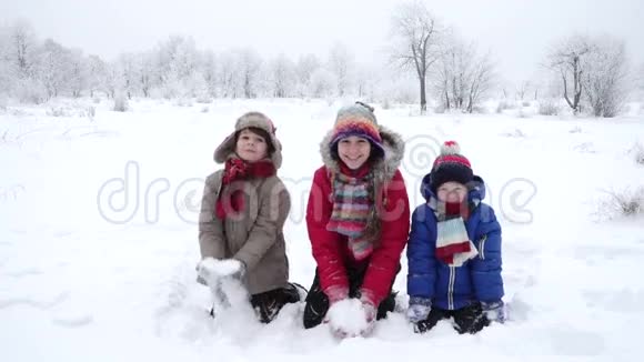 三个快乐的孩子在冬季公园扔雪慢动作视频的预览图