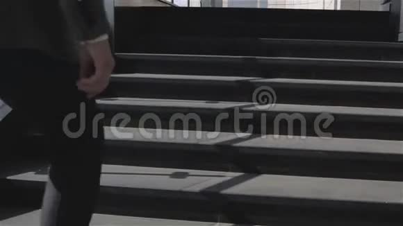 戴太阳镜的商人走上商务中心的楼梯停在栏杆附近视频的预览图