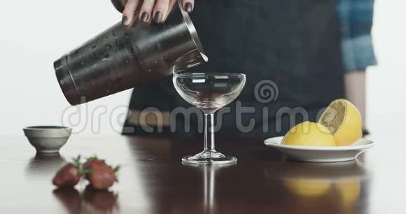 调酒师将鸡尾酒倒入玻璃杯的特写镜头视频的预览图