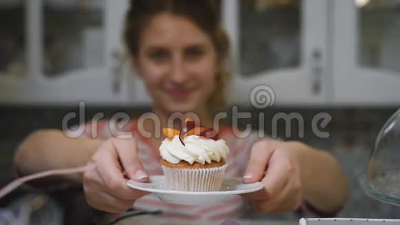糖果女孩藏在尾巴上双手捧着一个美味的蛋糕放在一杯小咖啡上视频的预览图