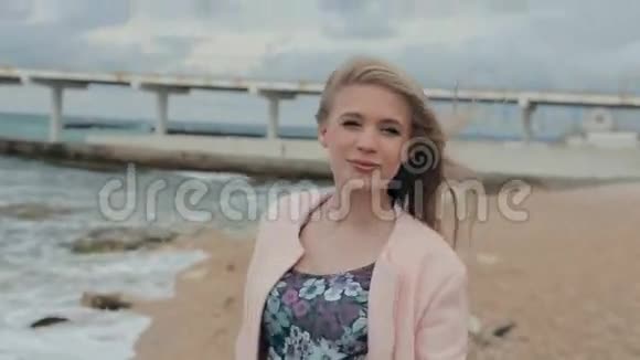 一个悲伤快乐的女孩在海滩上散步视频的预览图
