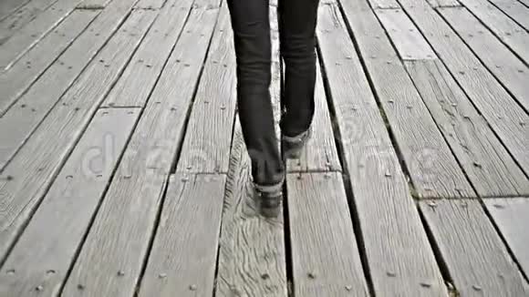 年轻女子独自走在木墩或桥上过河观点透视视频的预览图