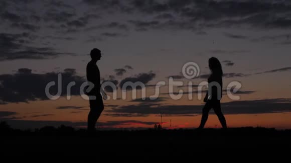 浪漫情侣剪影男人和女人在一起情人在夕阳下亲吻视频的预览图