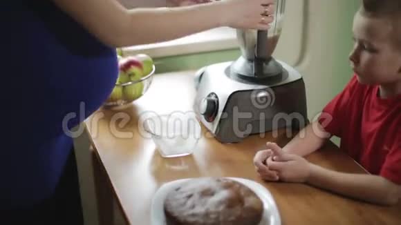 一位怀孕的母亲从搅拌罐中倒入奶油介绍一个玻璃碗视频的预览图