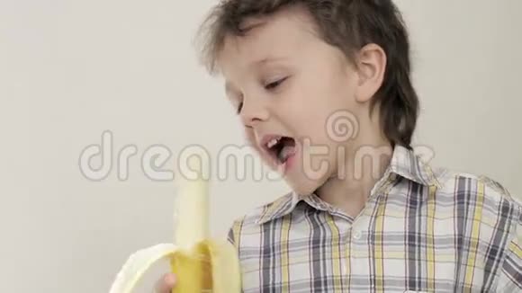 小男孩咬香蕉的肖像视频的预览图