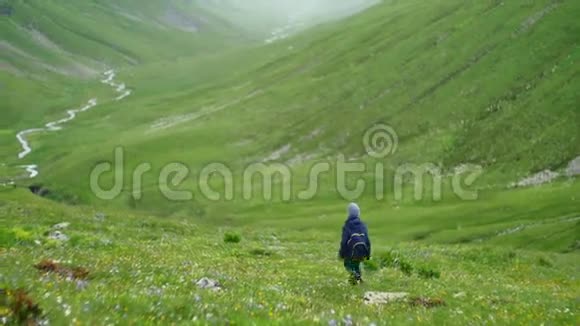 带背包徒步旅行的小男孩在风景优美的青山山谷和河流中徒步旅行视频的预览图