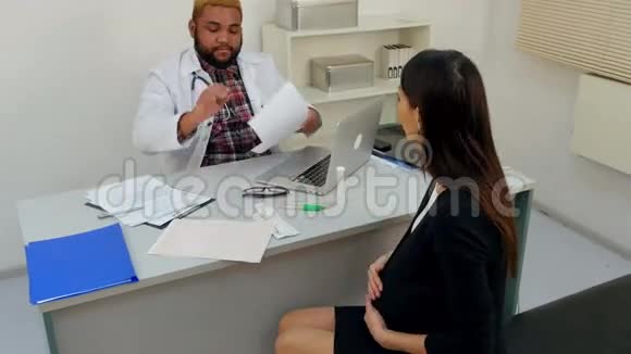 年轻孕妇拜访医生给他一些医疗文件视频的预览图