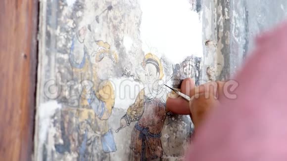 一位绘画艺术家的手在修理一幅中国画旧建筑墙体国画改造视频的预览图