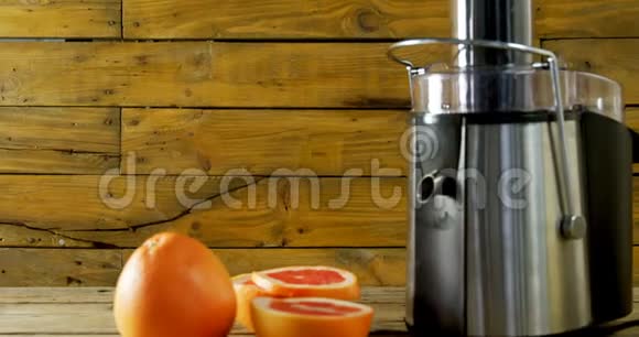 4k木桌上的葡萄柚和果汁机视频的预览图