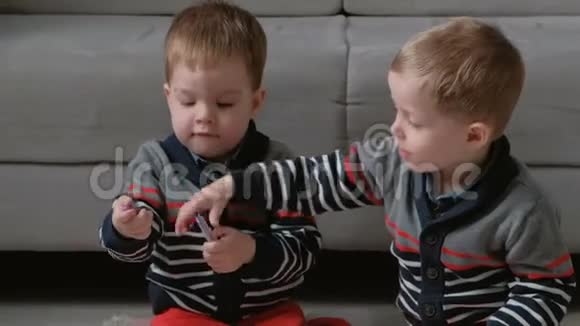 两个双胞胎兄弟蹒跚学步的孩子一起画坐在地板上的标记视频的预览图