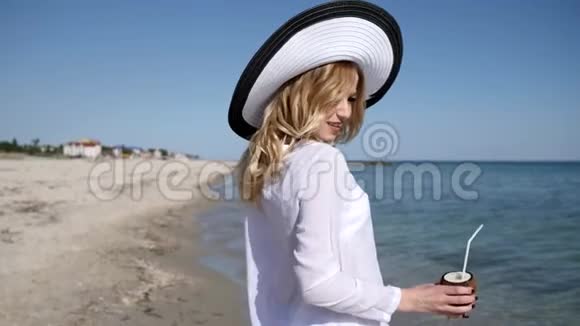 肖像美丽的女性戴着沙滩帽在海岸昂贵的度假视频的预览图