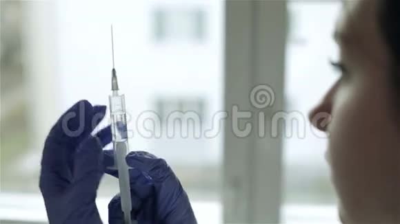 一位带着注射器准备注射的女医生视频的预览图