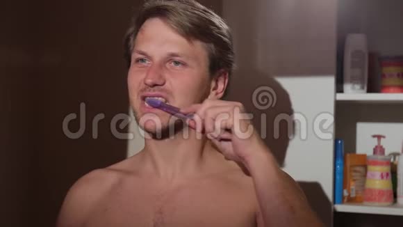 年轻人刷牙他赤裸着上身站在浴室里视频的预览图