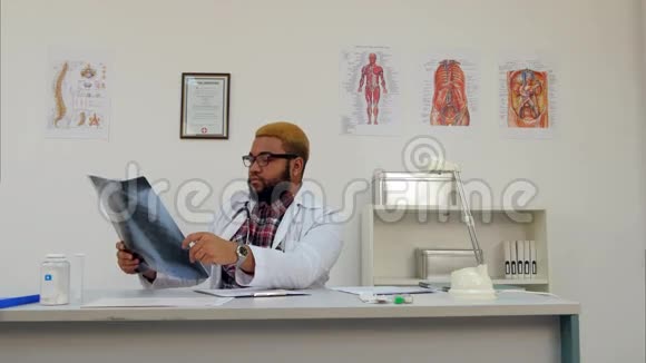 美国黑人医生分析X射线并在医务处做笔记视频的预览图