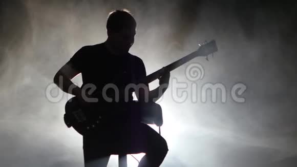 烟雾弥漫的音乐室的音乐家坐在椅子上弹吉他视频的预览图