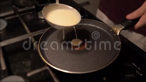 一个人把面团倒在锅里做煎饼男子烹饪煎饼视频的预览图