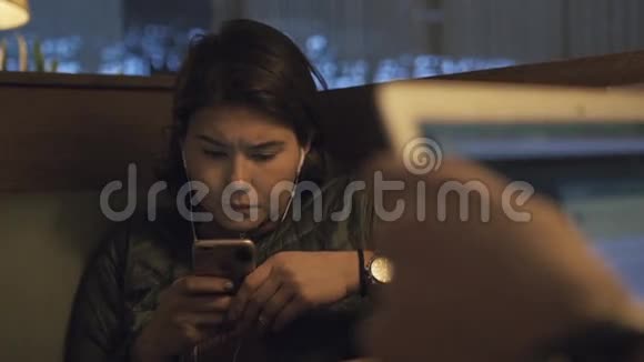 疲惫的旅行者女游客在机场休息时使用手机视频的预览图