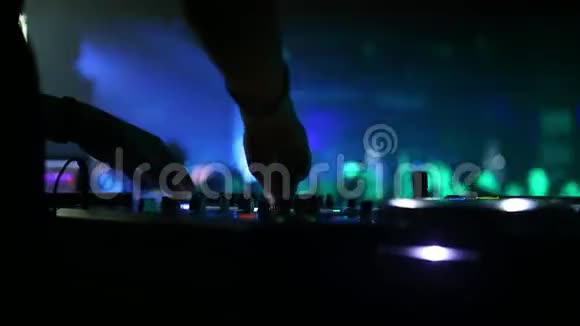 在前台是一个音响调音台用于DJ的工作在后台跳舞的人视频的预览图