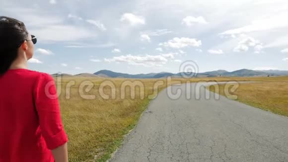 穿着红裙子在田野里散步的女孩视频的预览图