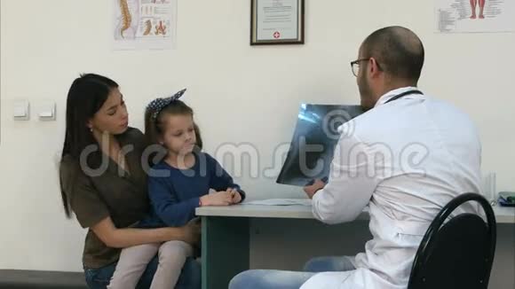 医生向抱着小女儿的母亲解释胸部X光图像视频的预览图