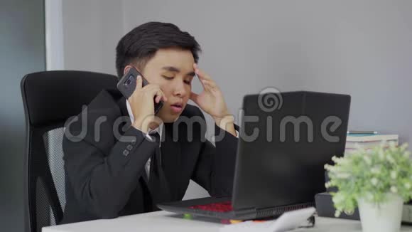 一个穿西装的郁闷男人在智能手机上说话视频的预览图
