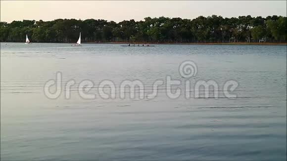 曼谷周日晚上许多人在公共公园湖上享受帆船和独木舟视频的预览图