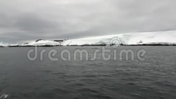 南极洲海洋中被遗弃的房屋水面和沙漠雪海岸线视频的预览图