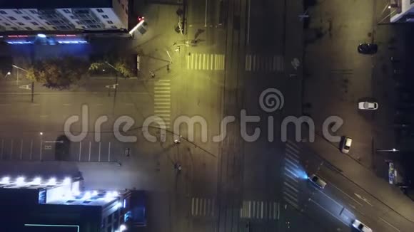 一个空中镜头的汽车驾驶通过小市中心的灯和交叉路口深夜剪辑空中飞行视频的预览图
