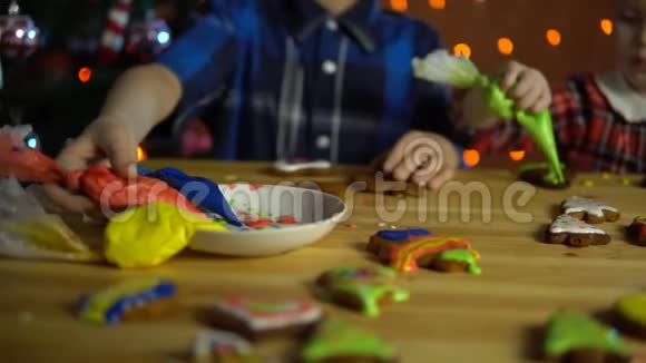 孩子们用五颜六色的釉面蛋糕覆盖在圣诞树旁边视频的预览图