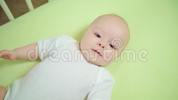 婴儿躺在家里的婴儿床上微笑视频的预览图