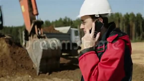 一位戴着白色头盔和红色夹克的建筑工人的老板正在用他的手机下订单视频的预览图