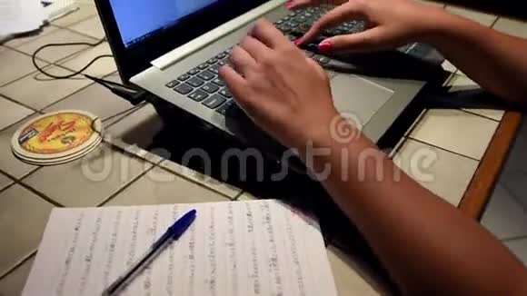 年轻女子的手在她的笔记本电脑里打字视频的预览图