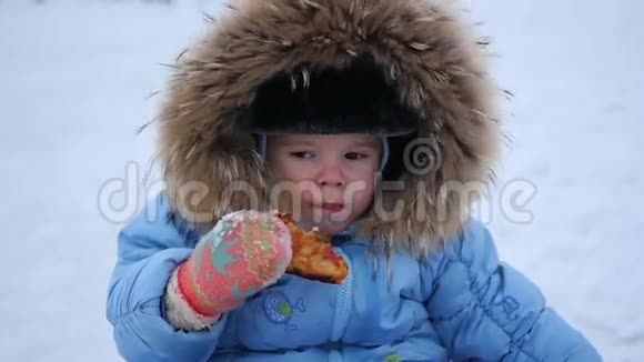 饥饿的孩子在户外吃披萨冬季视频的预览图