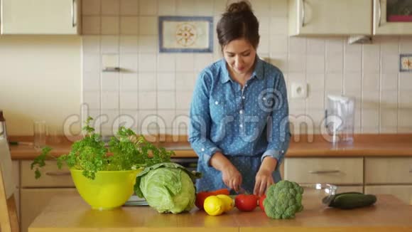 漂亮的年轻女人站在厨房的桌子上切蔬菜健康的生活方式有机食品纯素饮食视频的预览图